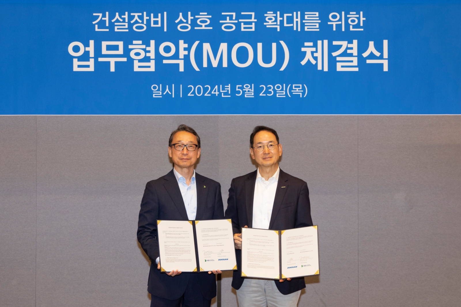 Doosan Bobcat Vice Chairman Scott Park (right) and HD Hyundai Infracore President Cho Young-cheul are taking a commemorative photo after signing the agreement on May 23rd.