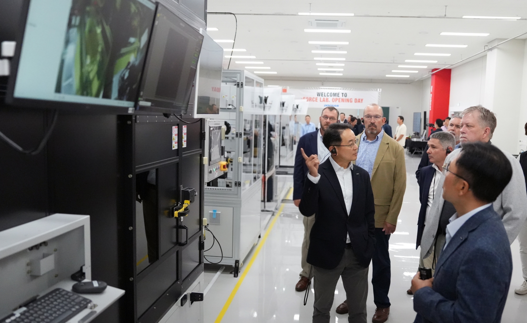 Employees attending the eFORCE LAB launch ceremony tour the facility and take a look at the battery pack research equipment.